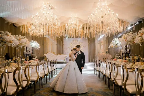 Elegant wedding decor with floral arrangements, candles, and modern stage design